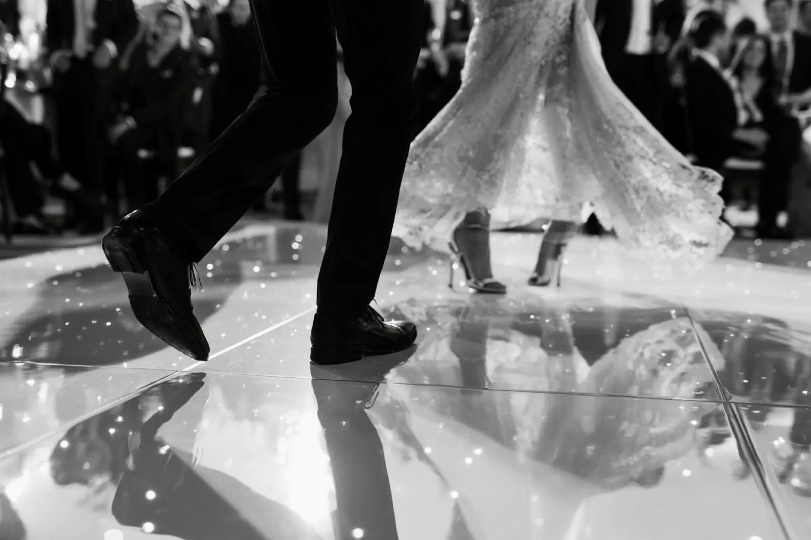 Feet on a mirrored dance floor, in black and white