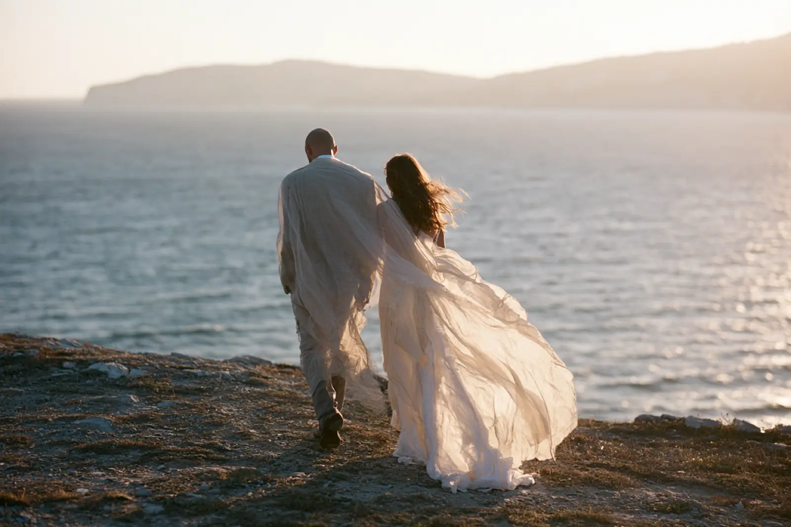 A newly married couple walking beside the sea