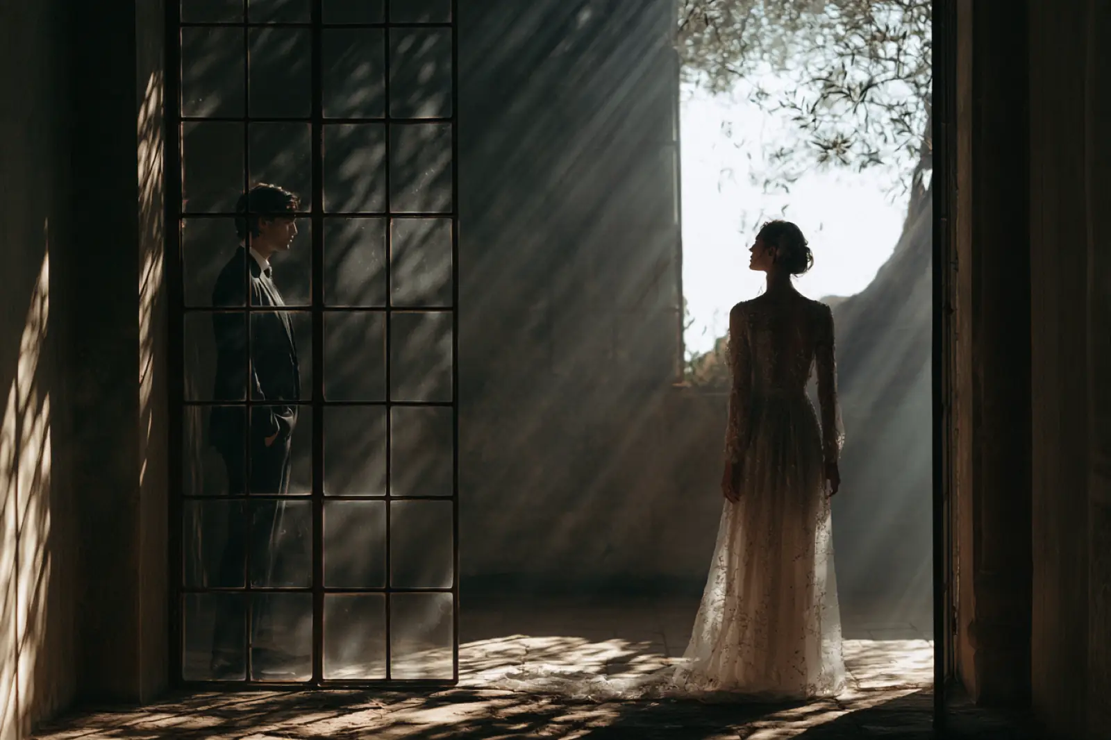 A bride silhouetted in a tall doorway before the ceremony