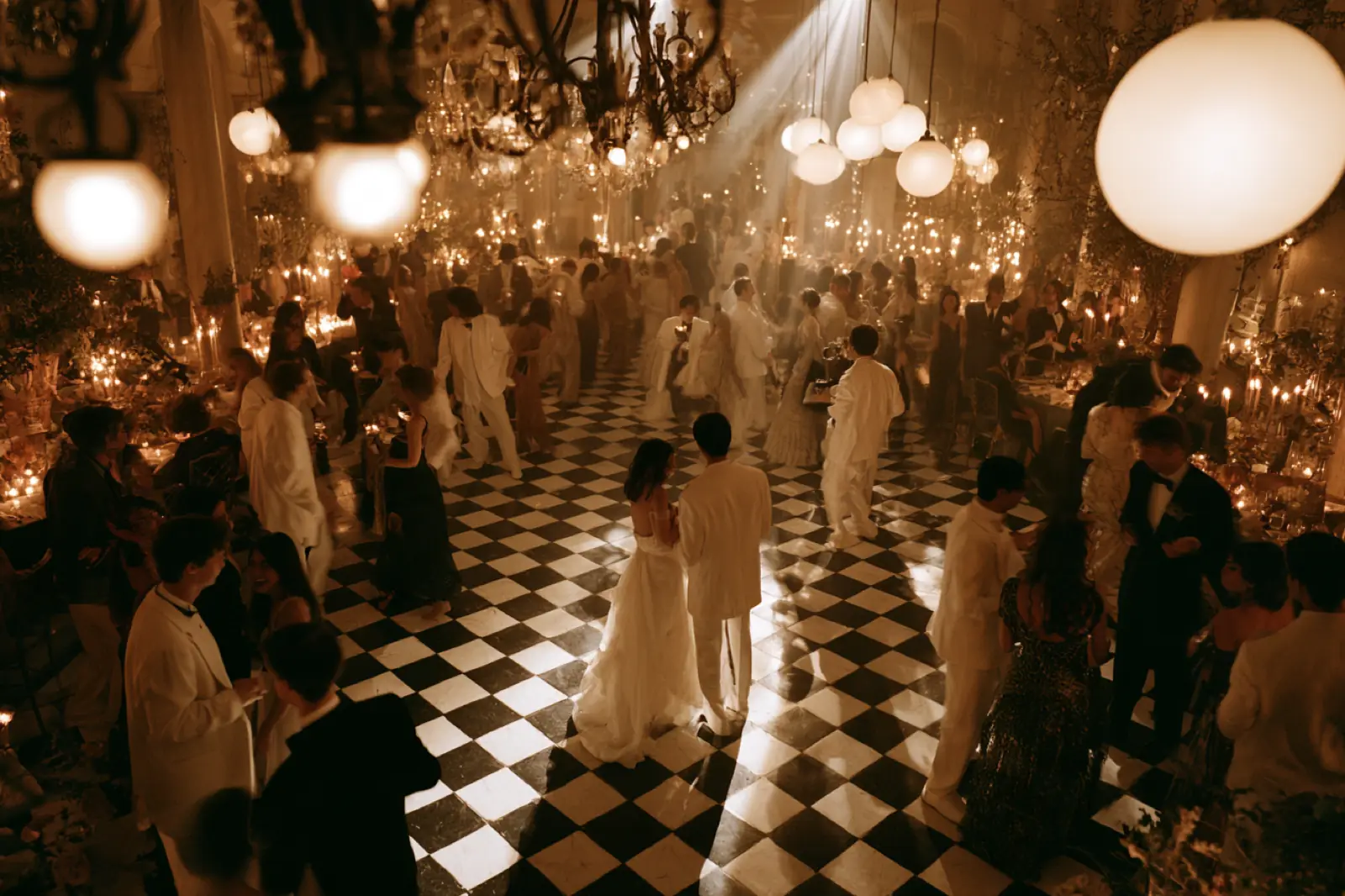A candlelit wedding reception seen from above as guests dance