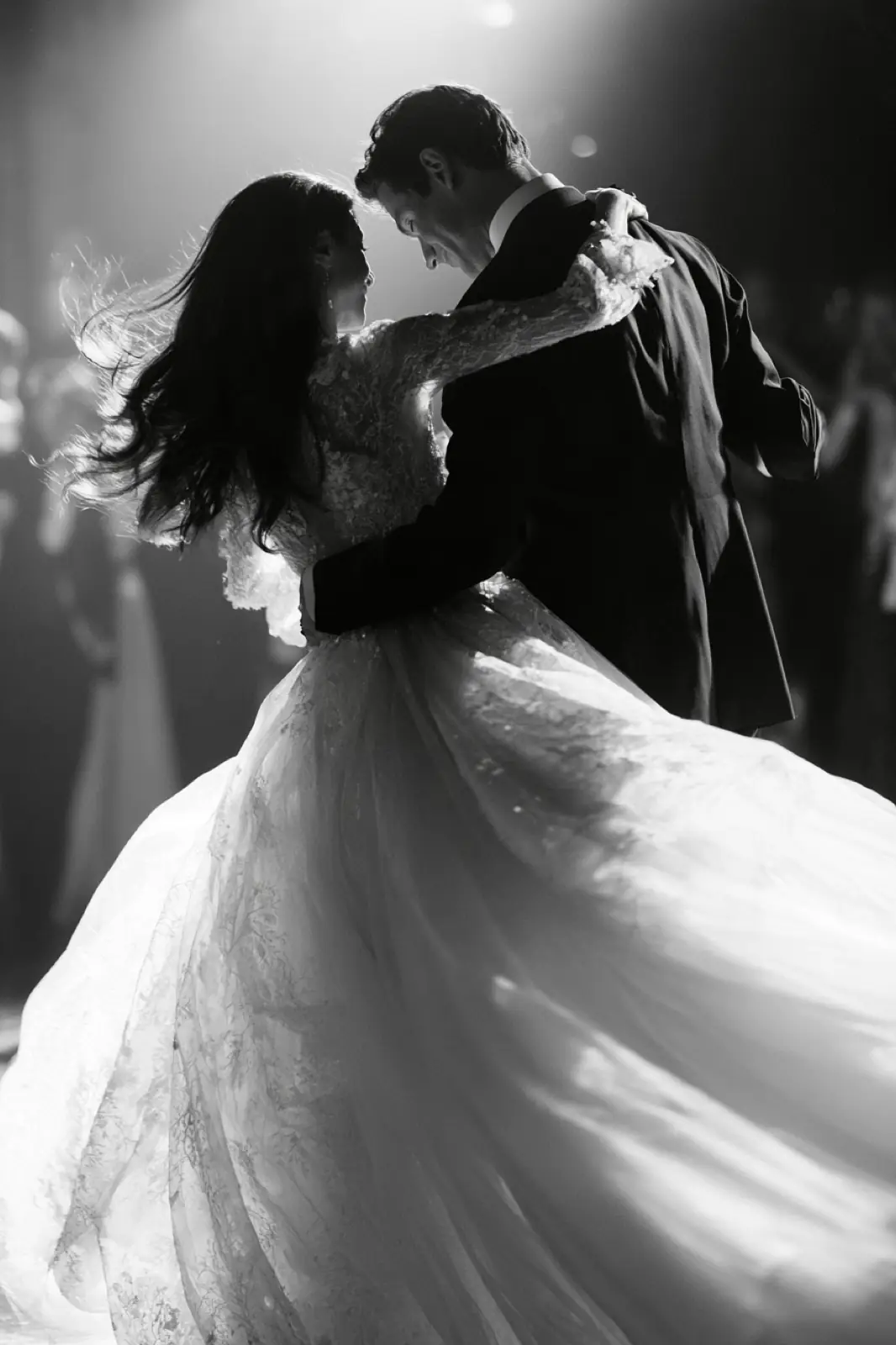 A couple dancing, her dress turning, in black and white