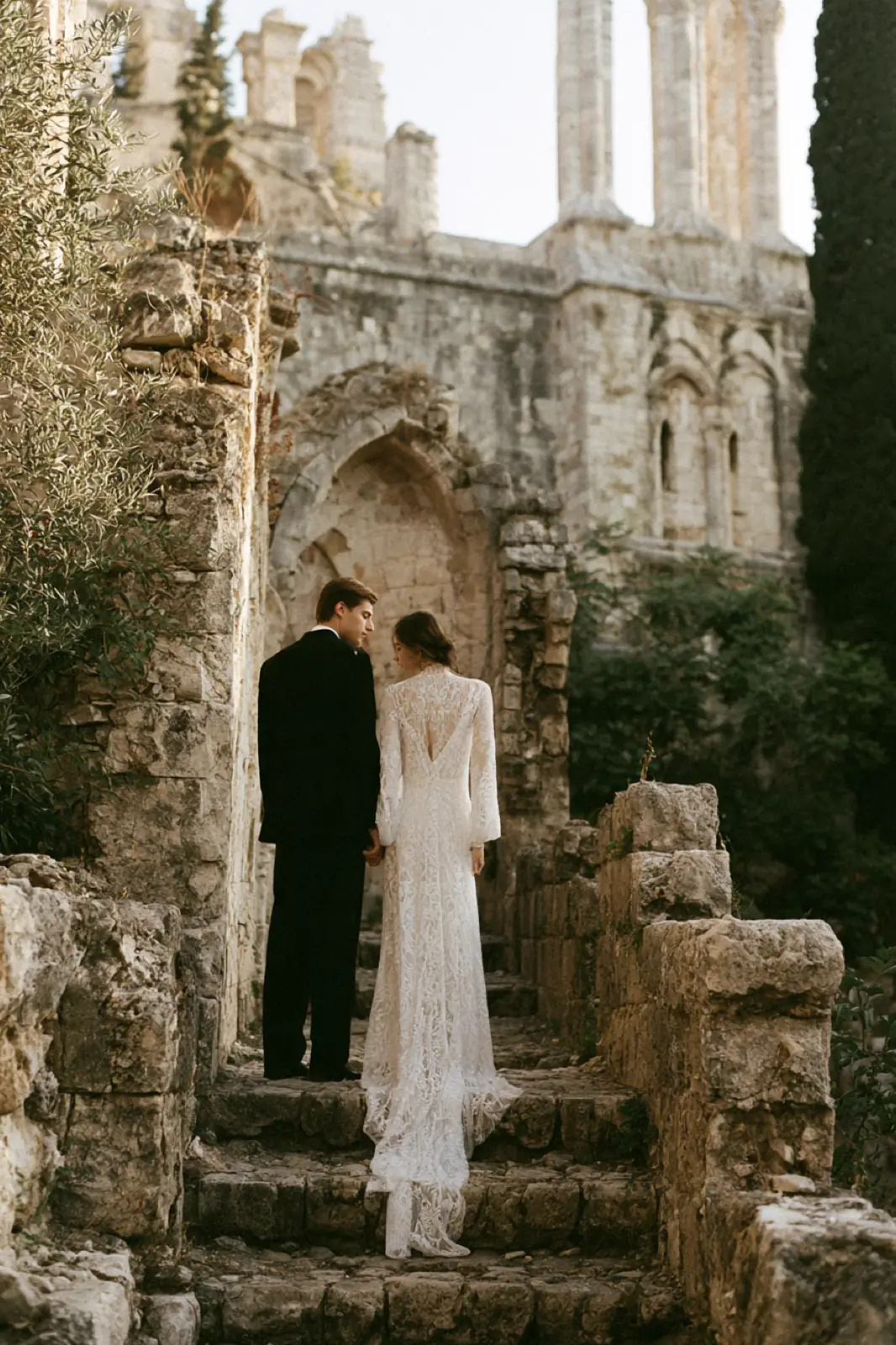 A couple on worn stone steps beneath a carved arch