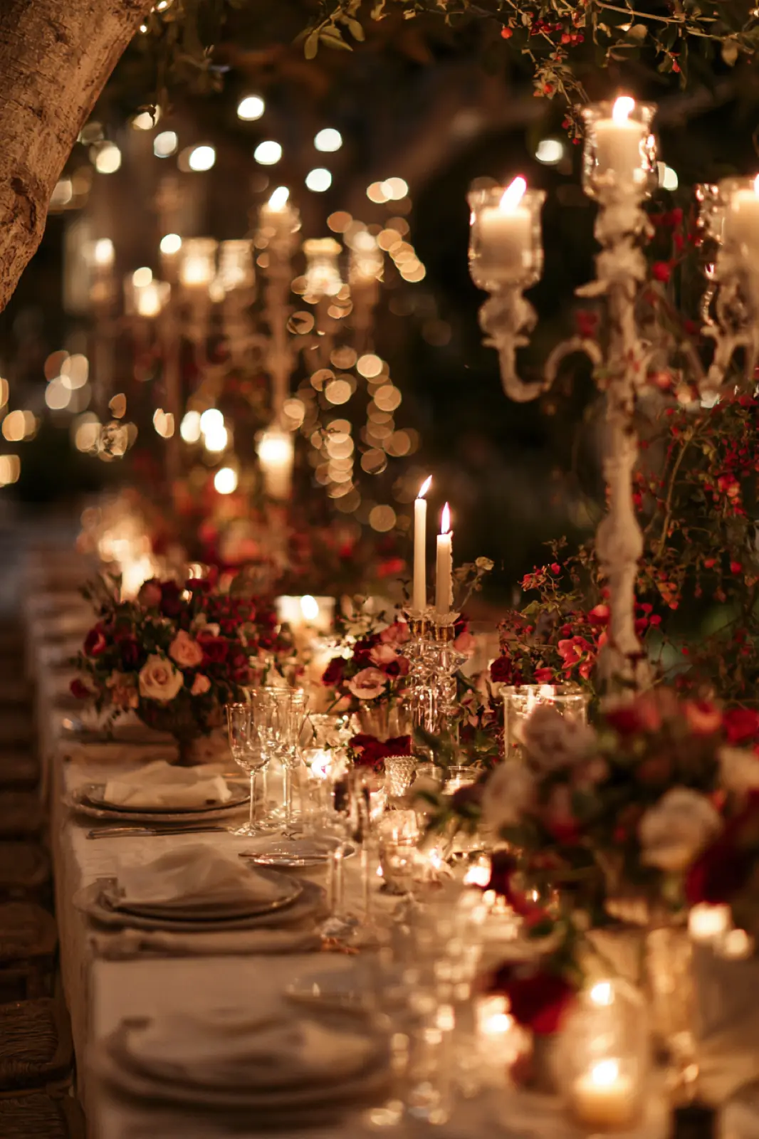 A candlelit table with low flowers and glasses