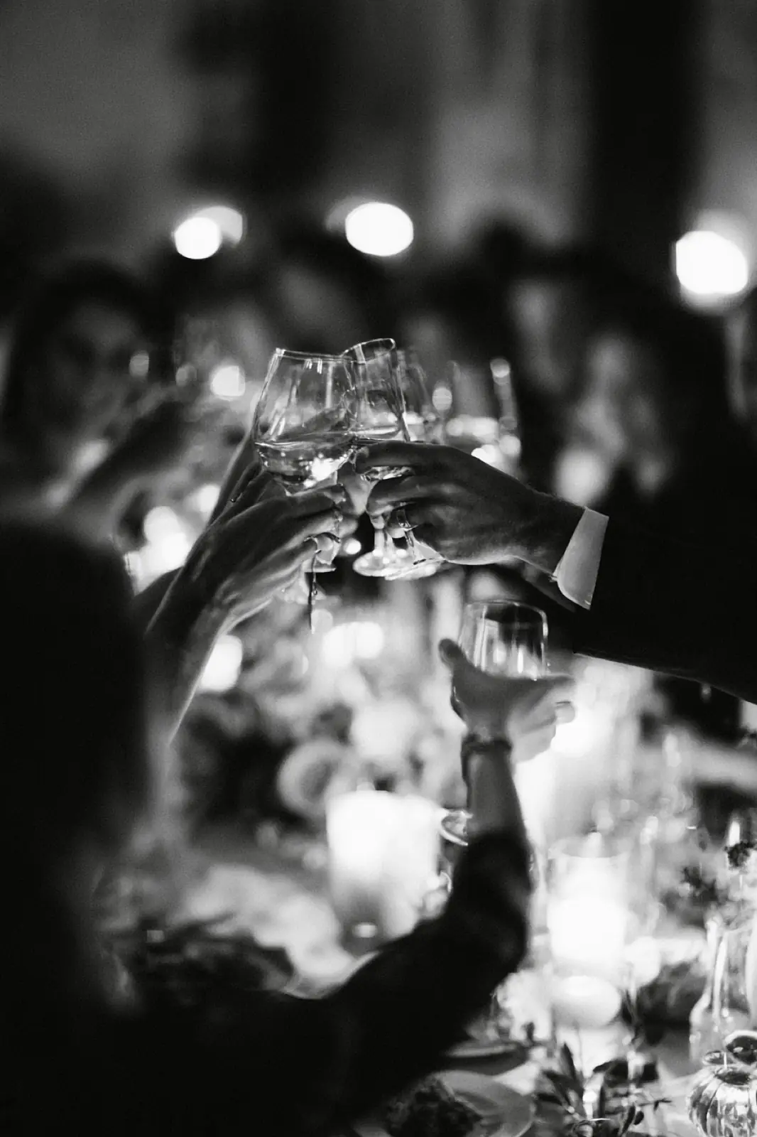 A bouquet raised above a crowded dance floor in black and white