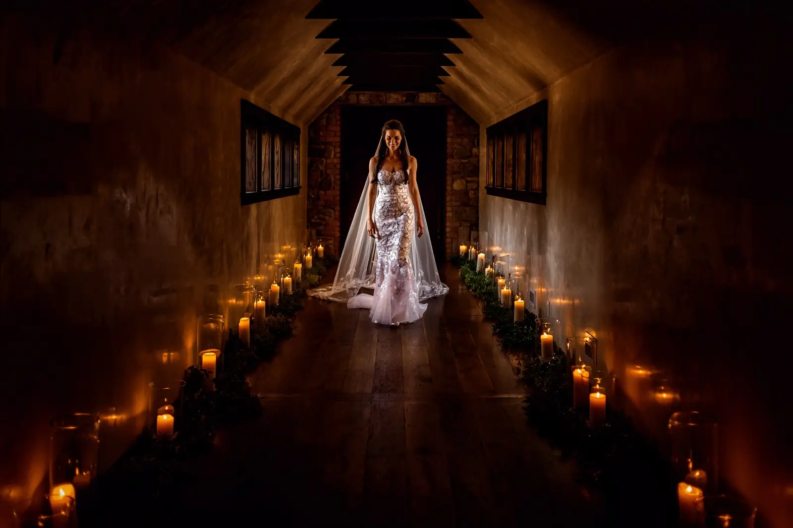 A bride at the far end of a candlelit hall