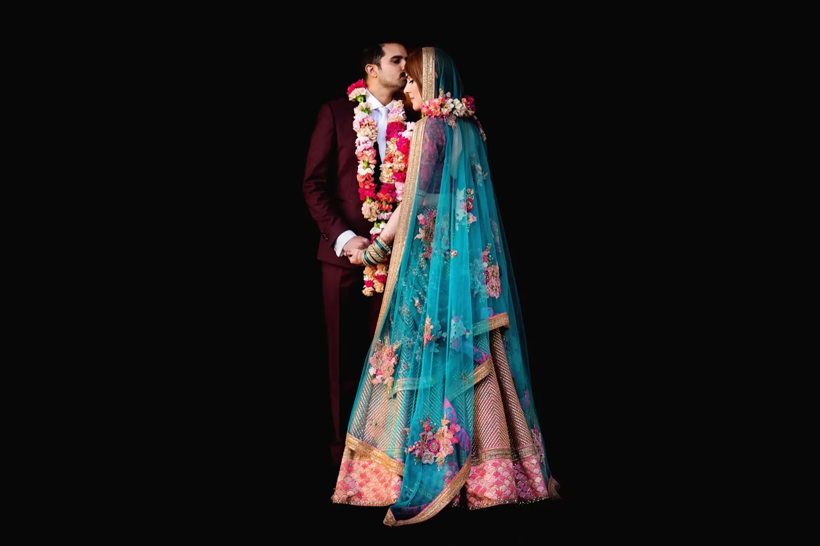 A couple in an embroidered shawl against the dark