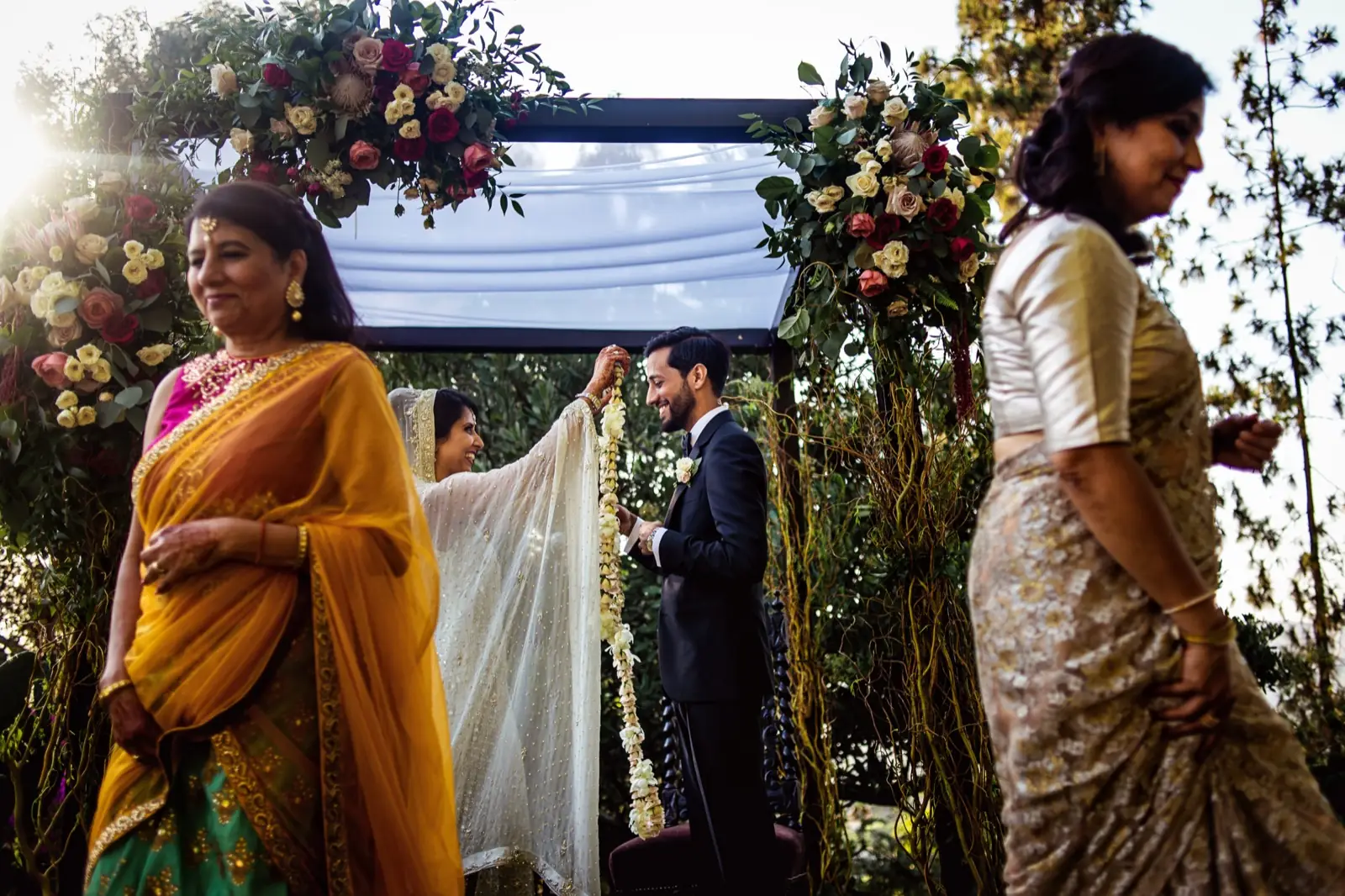 A ceremony under a flowered canopy, the bride in yellow