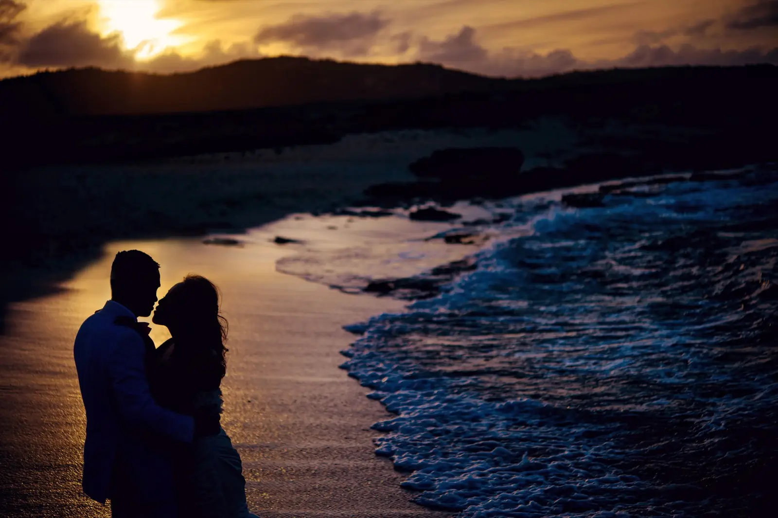 A couple by the sea at dusk, the last light on the water