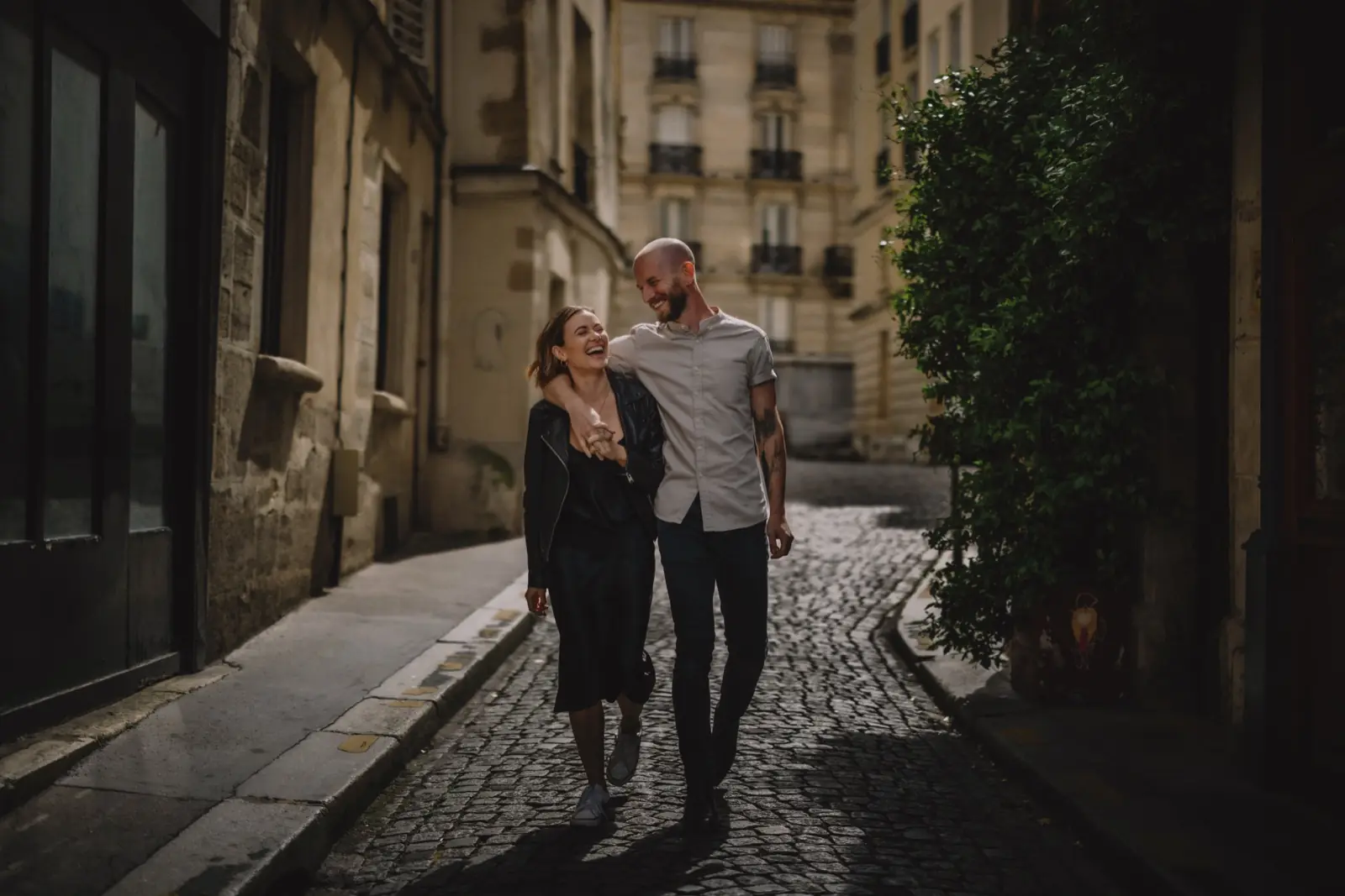 A couple walking arm in arm down a stone street