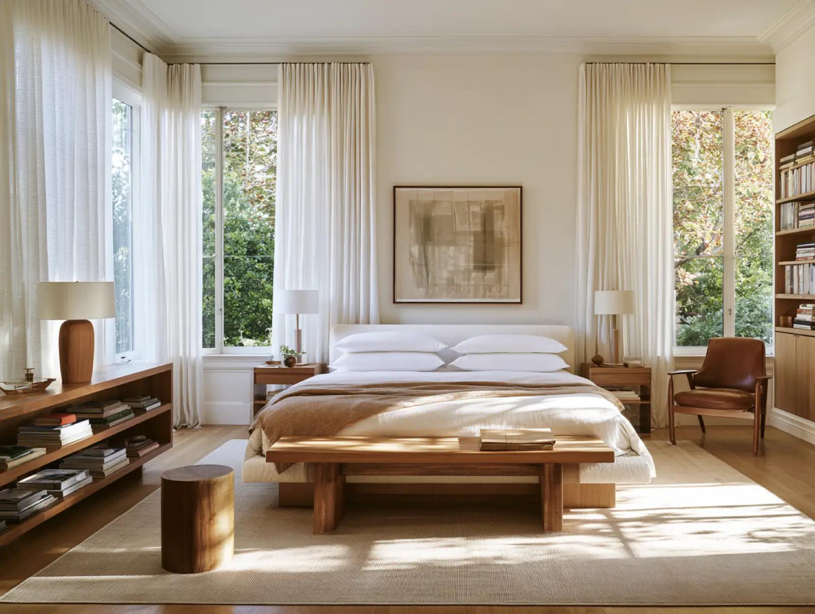A white bedroom, the curtains open to the garden