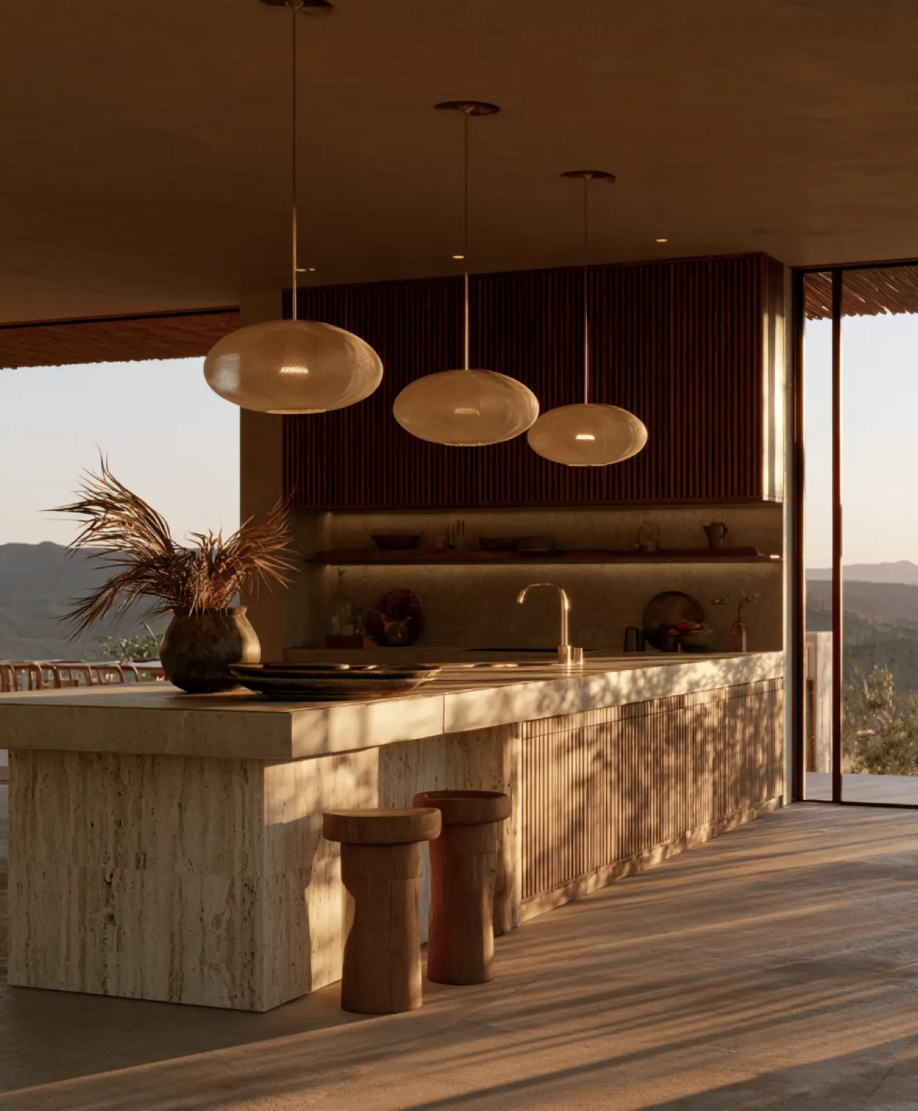 A stone kitchen island under three pendant lamps, open to the sea