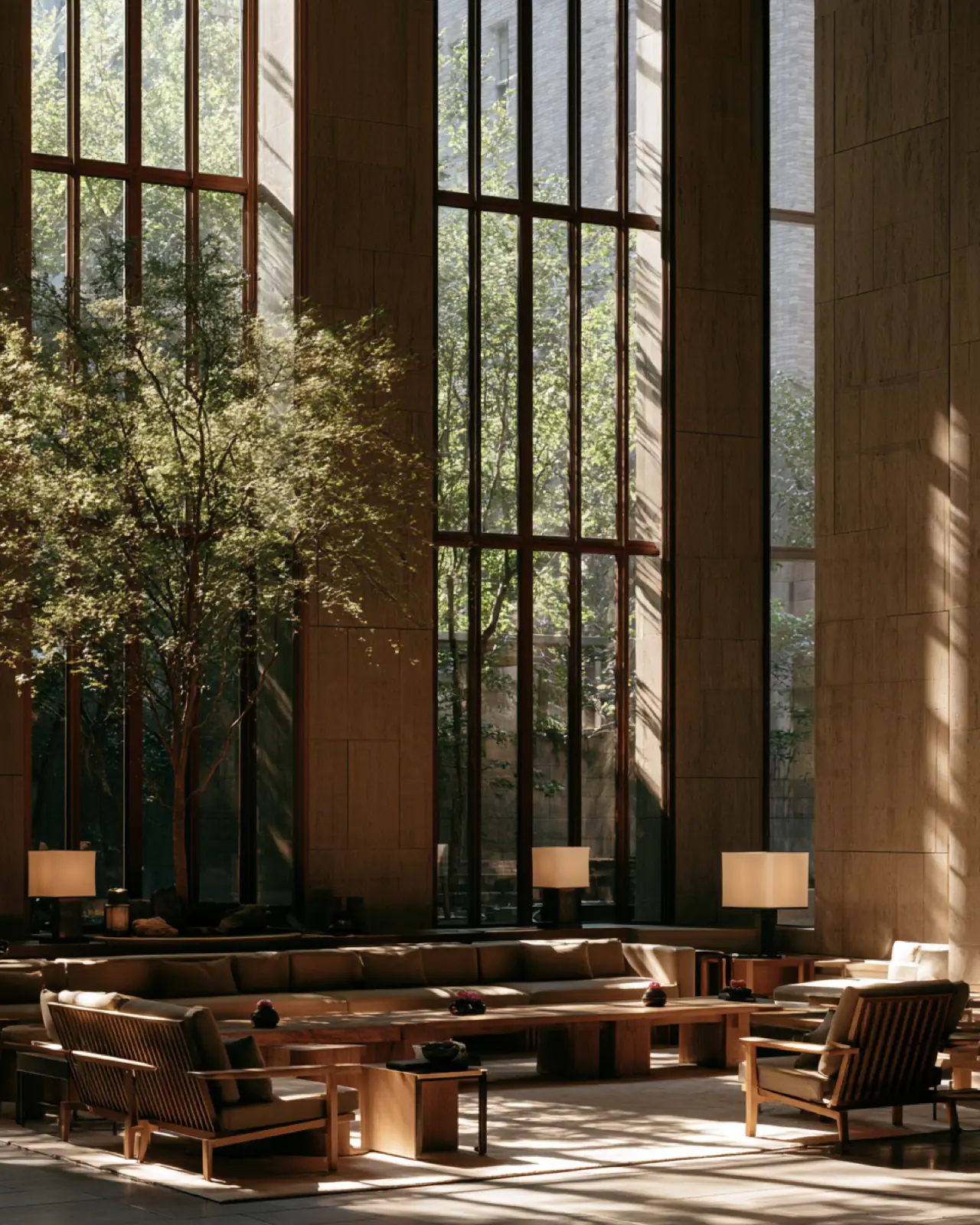 A tall timber room with trees behind floor-to-ceiling glass